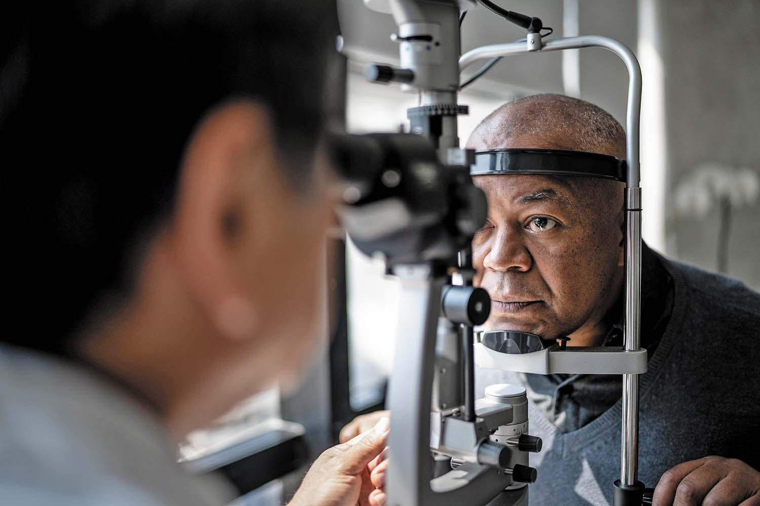 A mature man has his eyes examined by an eye doctor.